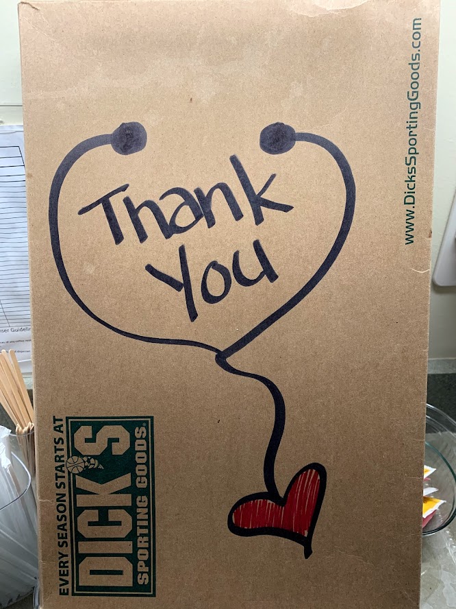 A brown cardboard box featuring handwritten text that says 'Thank You' inside a heart shape, along with a red heart graphic.